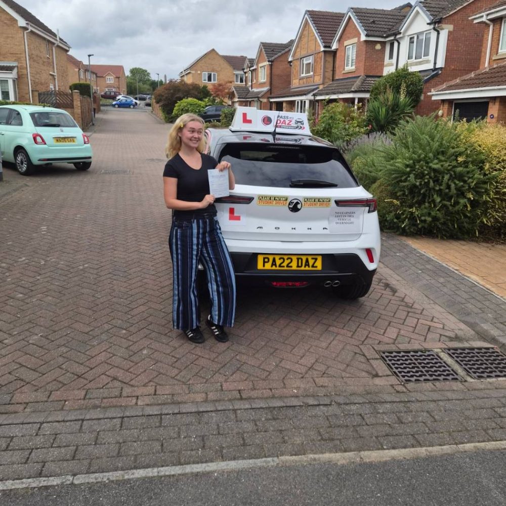 Pupil with her driving test pass certificate beside the Pass with Daz tuition car