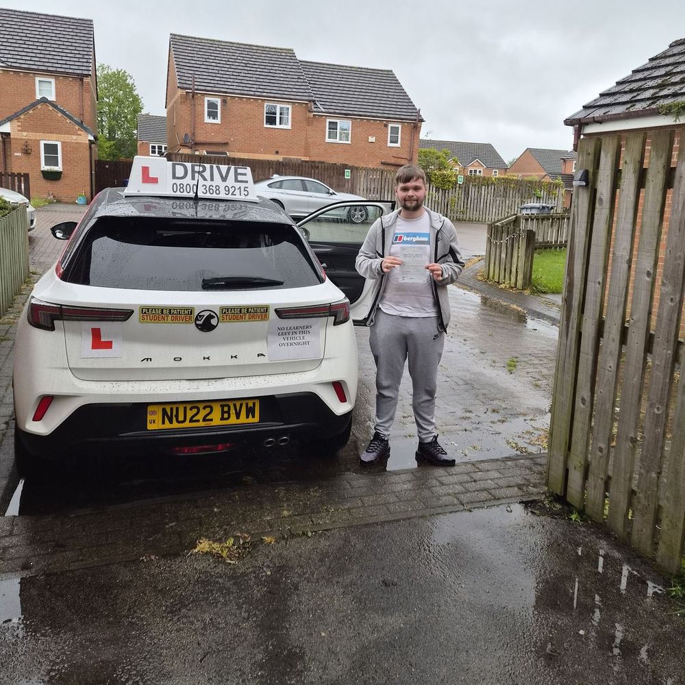 Pupil holding his pass certificate beside the Pass with Daz car after passing his driving test in Barnsley