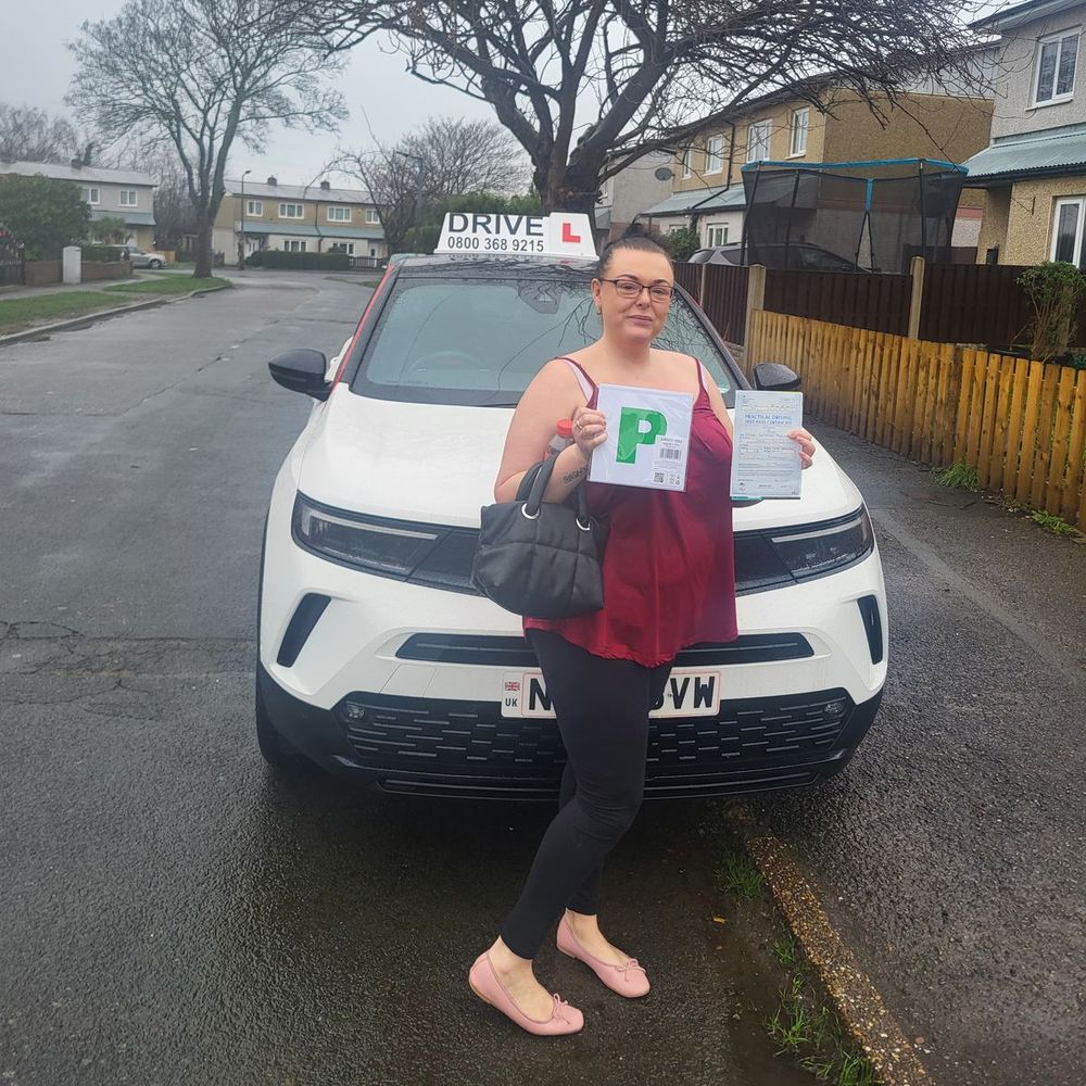 Pupil holding her P plate and pass certificate after passing her driving test with Daz