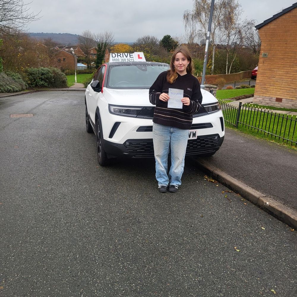 Learner driver with her driving test pass certificate in front of the Pass with Daz car in Barnsley